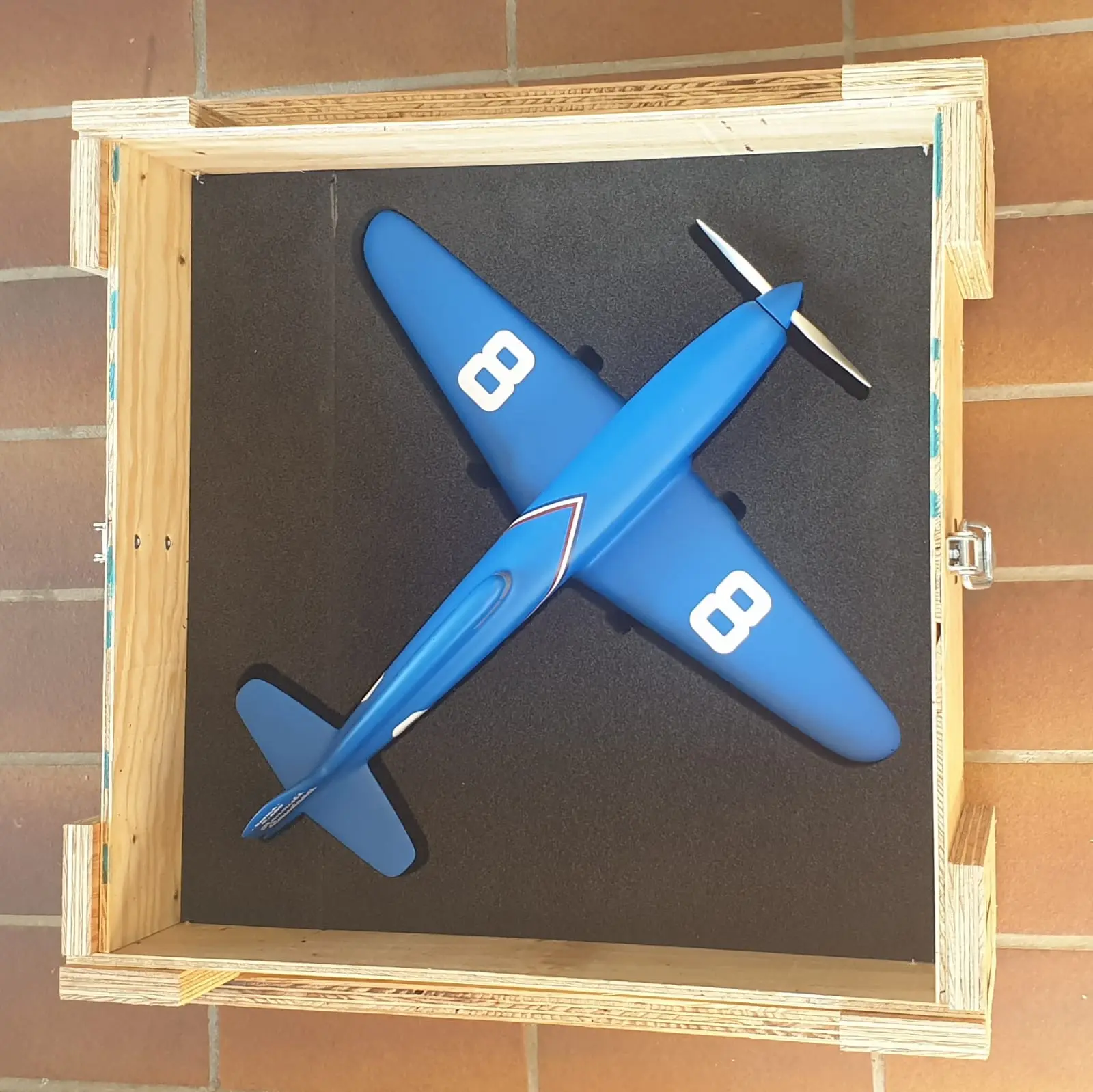 Maquette d’avion maintenue dans une caisse par un calage en mousse sur mesure